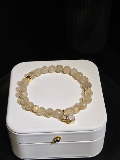 Golden Rutilated Quartz Beaded Bracelet with Gold Charm in a white jewelry box